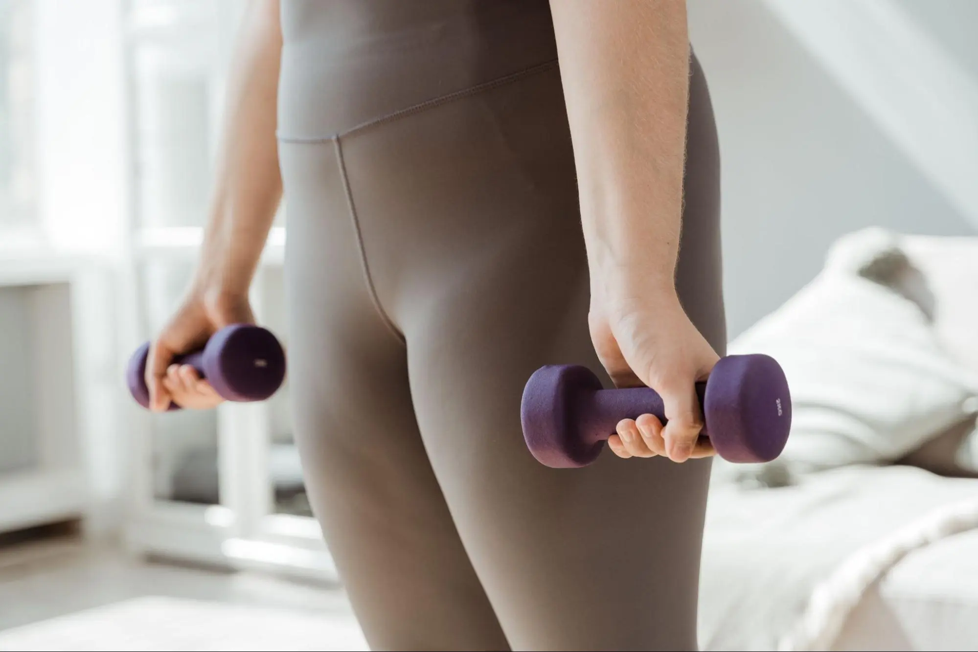 a person holding two weights for at-home exercise