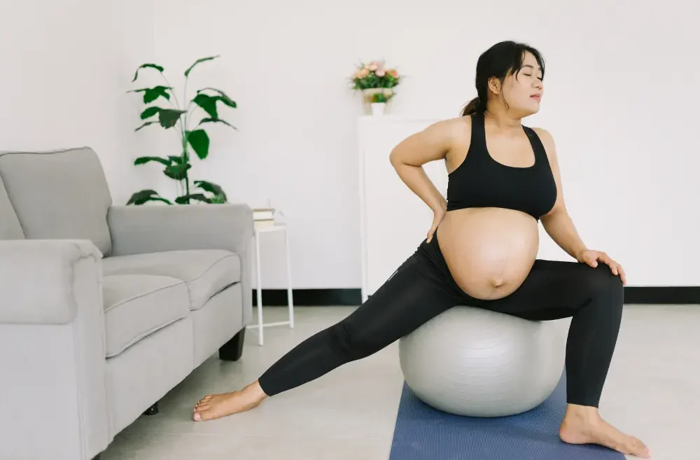 Pregnant person exercising on a balance ball