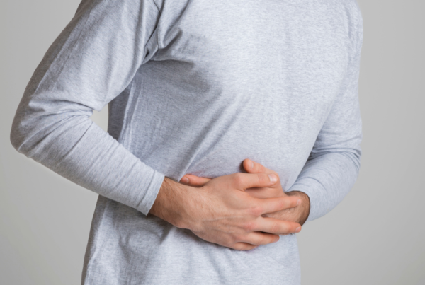 Man with IBS holding his stomach in pain