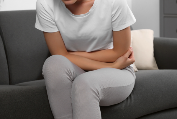 Person holding their abdomen in pain due to levator ani syndrome