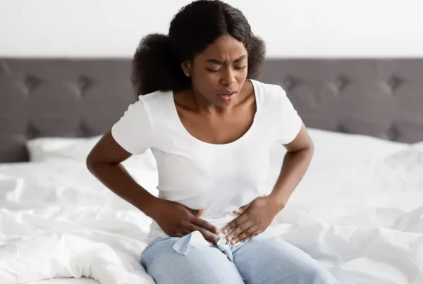 Person experiencing period pain holding their pelvic area