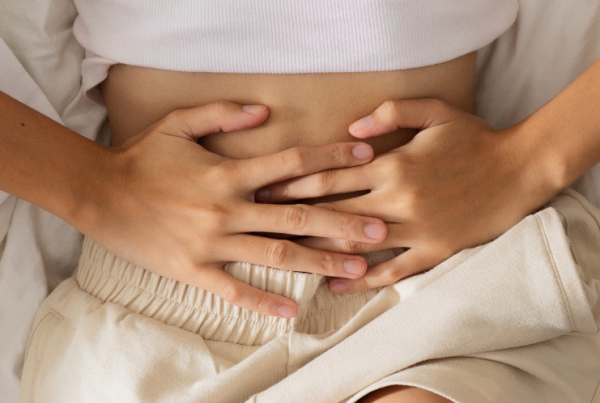 Person laying down and holding their lower abdomen