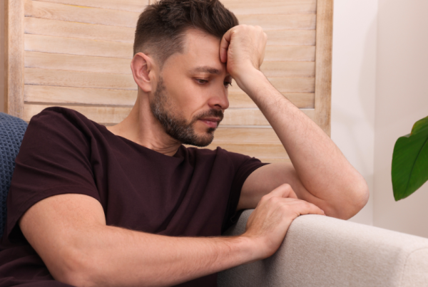 Man sitting on a couch looking frustrated