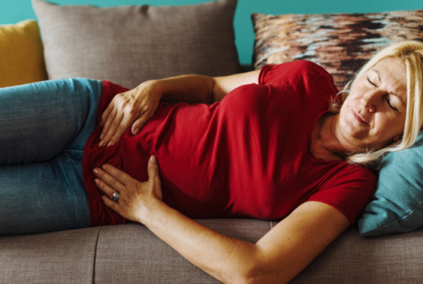 person lying down on a couch holding their pelvis