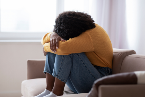 Frustrated person sitting with their head resting on their knees