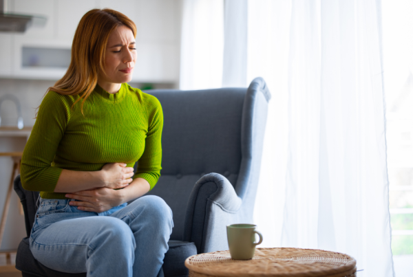 Woman sitting in pain while holding her abdomen