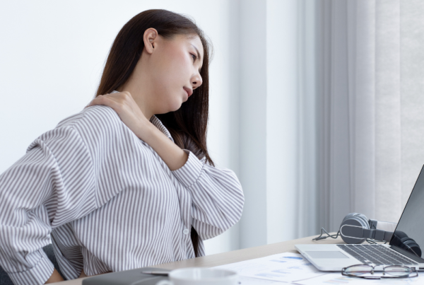 Person sitting at a desk and experiencing shoulder pain