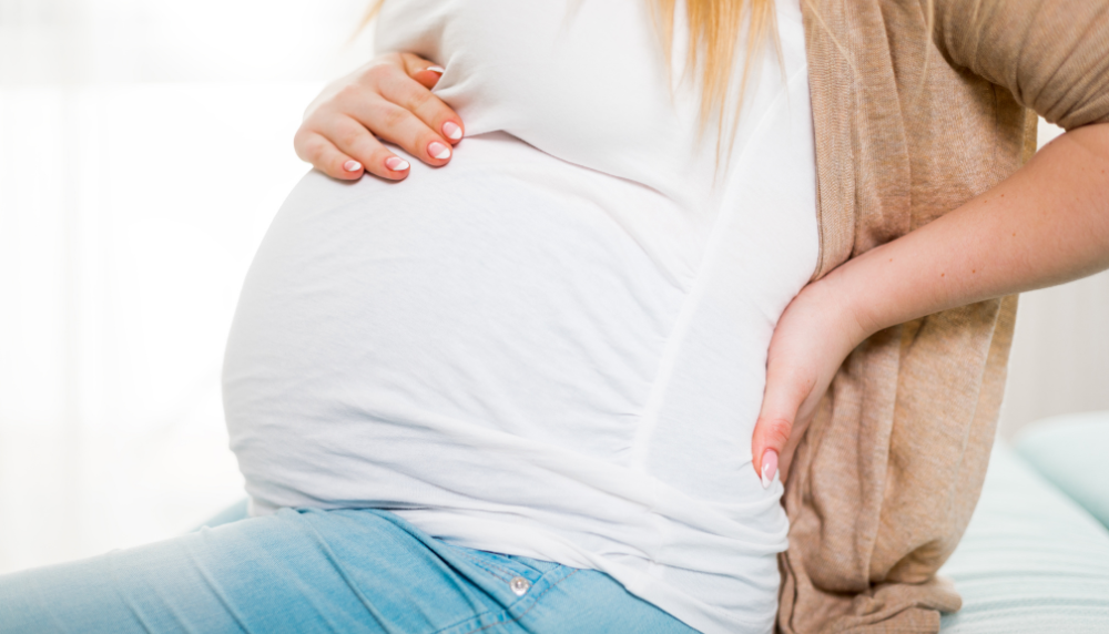 Person with lower abck pain due to pregnancy
