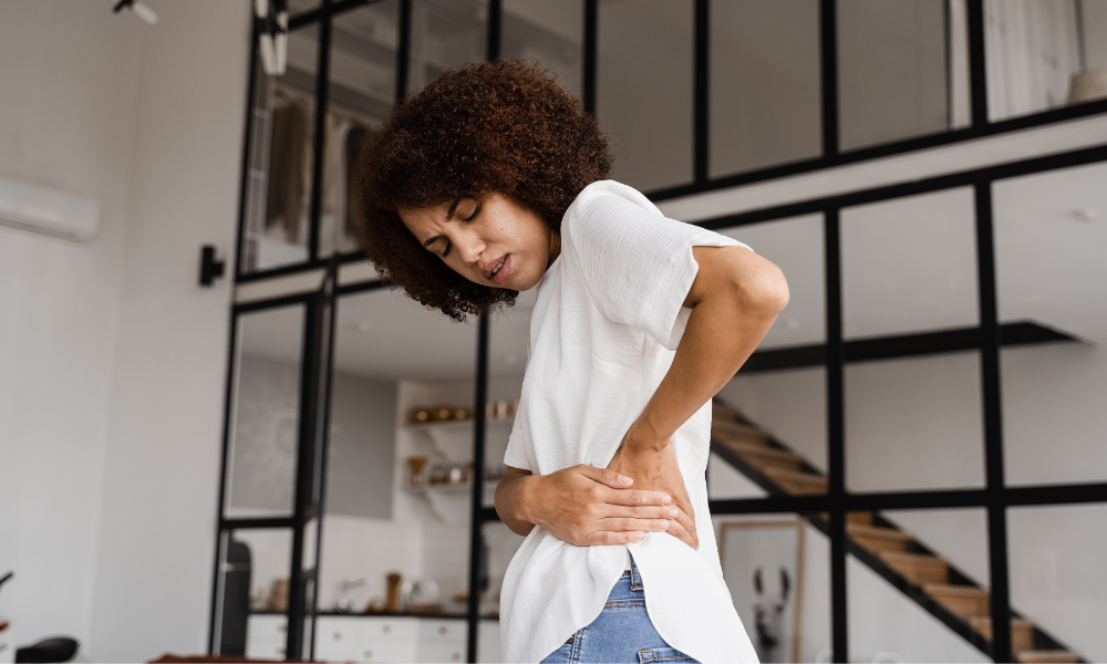 Person holding their side from pelvic pain