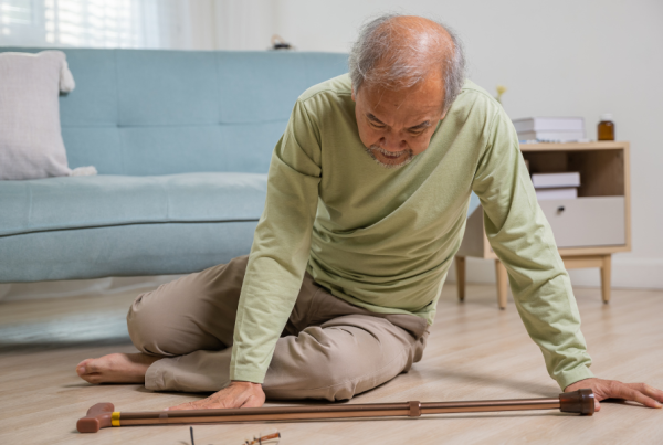Older man sitting on the floor with his cane, presumably after a fall