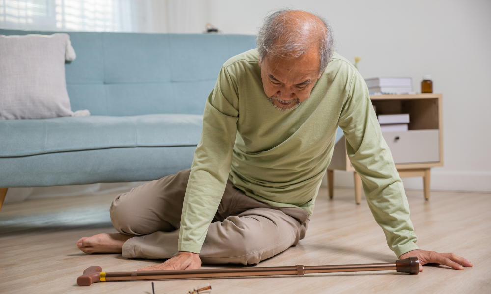 Older man sitting on the floor with his cane, presumably after a fall