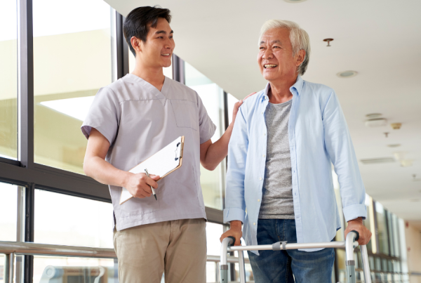 Physical therapist walking with a patient who is using a walker